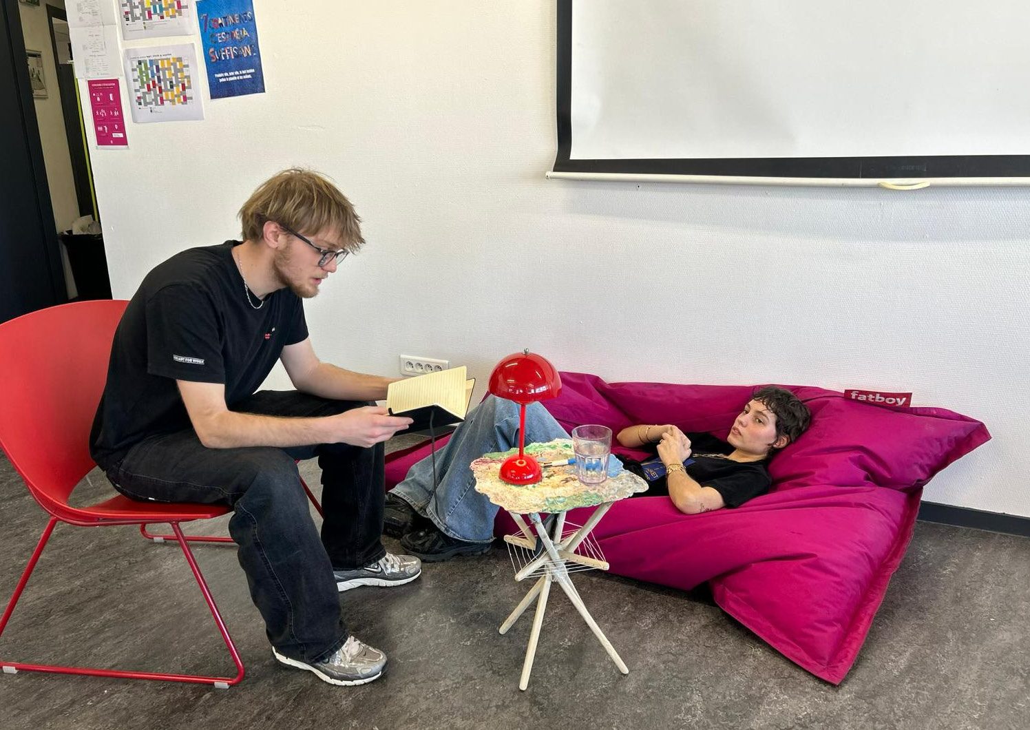 Deux étudiants testant la table d'appoint avec un pouf Fatboy